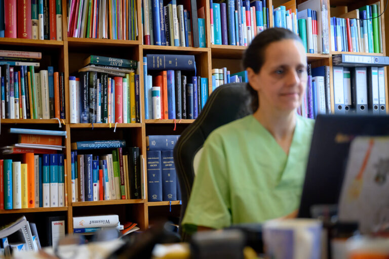 a woman sitting in front of a book shelf